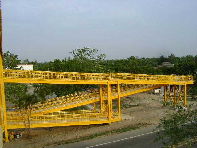 Puente peatonal metálico amarillo en Ponedera, Atlántico